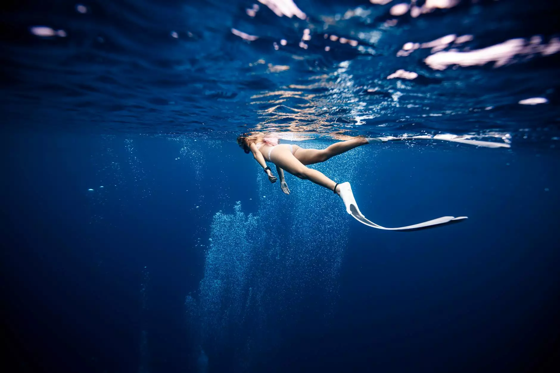A swimmer beneath the rippling surface of blue water